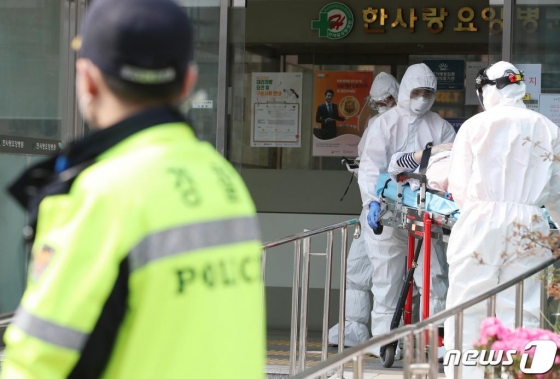 대구 서구 비산동 한사랑요양병원에서 19일 오전 보호복을 착용한 119구급대원이 확진자를 구급차로 옮기고 옮기고 있다./사진=뉴스1