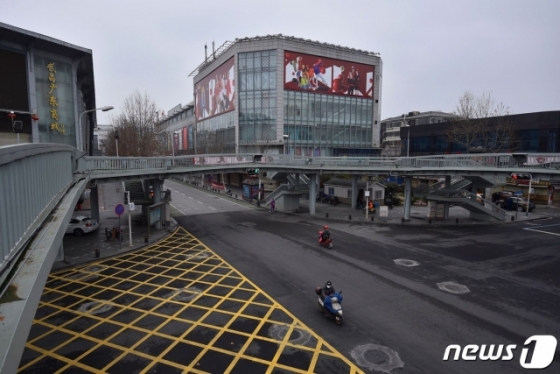 (우한 AFP=뉴스1) 우동명 기자 = 26일 (현지시간) 코로나 19 발원지인 후베이성 우한의 텅 빈 거리에 오토바이만이 달려가고 있다. ⓒ AFP=뉴스1