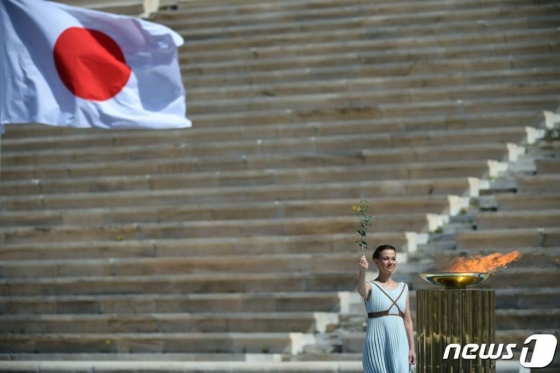그리스 배우 산티 게오르기오가 19일 (현지시간) 아테네에서 열린 도쿄 올림픽 성화 인수식에서 성화를 들고 있다. / 사진=AFP(뉴스1)