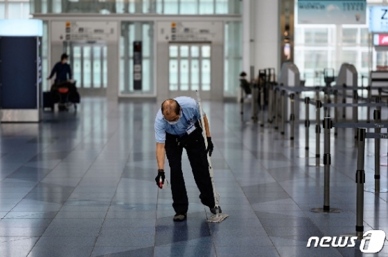 마스크를 착용한 청소부가 지난 10일 일본 도쿄 하네다 국제공항 출국장에서 바닥 청소를 하고 있다. © AFP=뉴스1