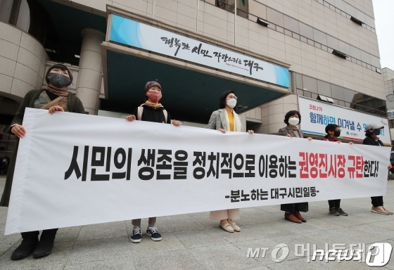 (대구=뉴스1)공정식 기자 =지난 26일 오후 대구시청 앞에서 분노하는 대구시민이라고 밝힌 일부 시민들이 "시민의 생존을 정치적으로 이용하는 권영진 시장 규탄한다"라고 적힌 현수막을 펼쳐 보이고 있다. 권 시장은 전날 오전 대구시의회 임시회 도중 코로나19 피해 지원 긴급생계자금 지급 시기와 관련된 지적을 받자 해명이나 양해를 구하지 않고 갑자기 퇴장해 물의를 빚었고, 26일 오후 시의회에서 열린 제273회 임시회 본회의를 마치고 본회의장을 나오던 중 갑자기 쓰러져 병원으로 옮겨졌다. /사진제공=뉴스1