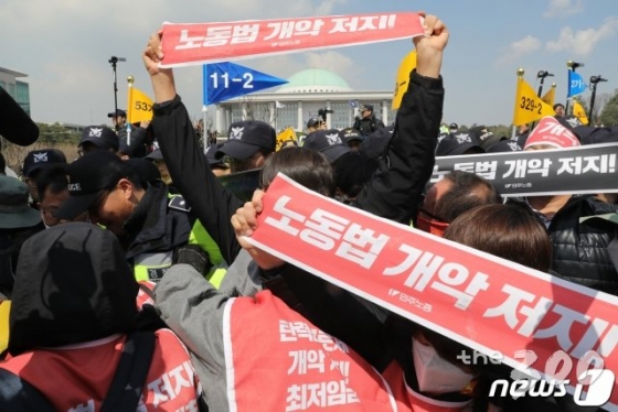 (서울=뉴스1) 임세영 기자 = 민주노총 관계자들이 지난해 4월3일 오전 서울 여의도 국회 정문 앞에서 노동법 개악 저지 등을 촉구하며 정문 담장을 부수고 국회 경내로 진입을 시도하고 있다. 2019.4.3/뉴스1