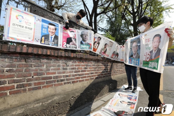 (서울=뉴스1) 이광호 기자 = 16일 오전 서울 종로구 동숭길에서 이화동주민센터 직원들이 제21대 국회의원선거 벽보를 철거하고 있다.2020.4.16/뉴스1