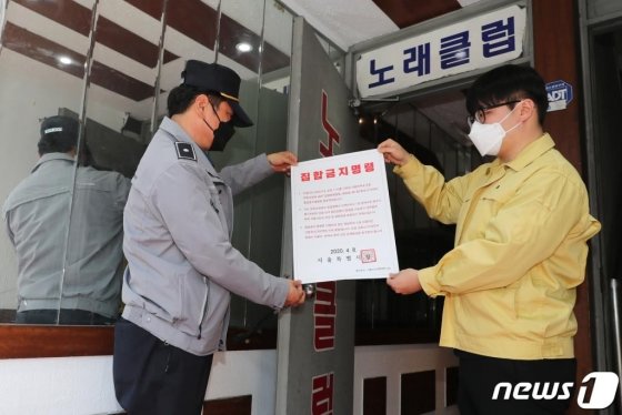  서울 성동구 보건소 관계자와 경찰이 9일 관내 유흥업소에서 집합금지 명령서를 붙이고 있다.(성동구청 제공) / 사진 = 뉴스 1