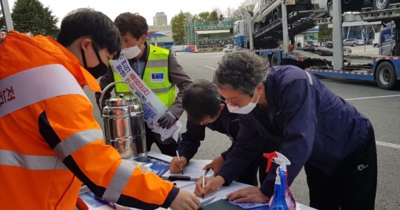 도로공사 직원이 고속도로 휴게소에서 화물차 운전자에게 '안전운전 실천 1만명 서약'을 받고 있다./사진=도로공사 제공
