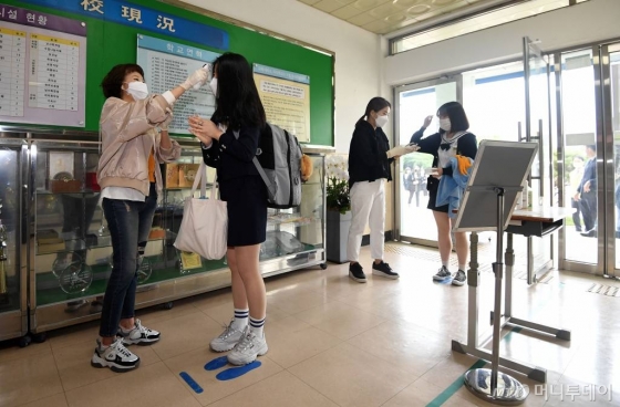 코로나 19 여파로 미뤄졌던 고등학교 3학년 등교일인 20일 서울의 한 고등학교에서 3학년 학생들이 교실 입실 전 체온을 측정하고 있다. 2020.5.20 / 사진=김휘선 기자 hwijpg@