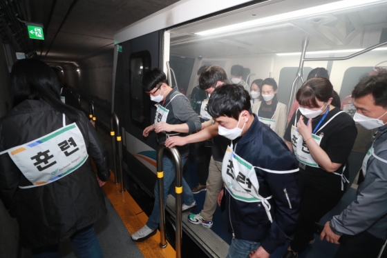 지난 21일 오후 인천공항 셔틀트레인(인천공항 내 무인열차) 화재와 수하물처리시설 장애상황을 가정해 실시된 ‘인천공항 비상 합동훈련’에서 훈련에 참가한 가상승객들이 셔틀트레인(인천공항 내 무인열차) 화재발생 현장에서 대피하고 있다. /사진제공=인ㅌ천국제공항공사
