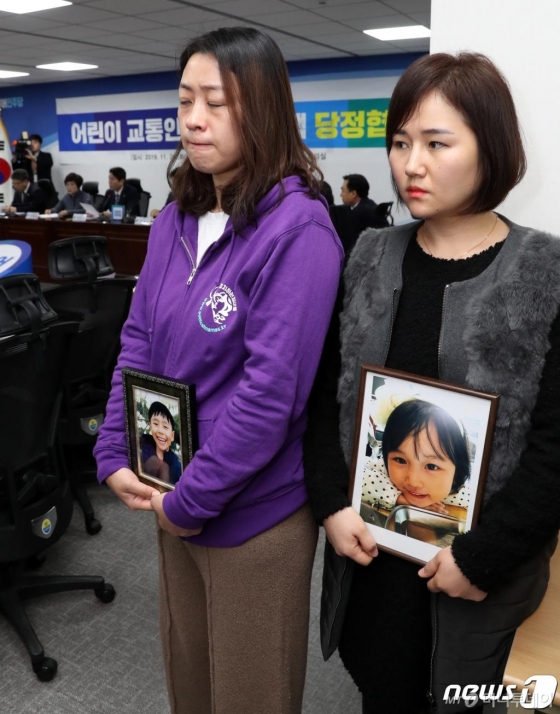 (서울=뉴스1) 이종덕 기자 = 26일 서울 여의도 국회 의원회관에서 열린 어린이 교통안전 강화 대책 당정협의에 고 태호군 어머니 이소현씨와 고 해인양 어머니 고은미씨가 고인의 영정을 든 채 회의를 지켜보고 있다. 이날 회의에서는 어린이 보호구역에 안전 장비 설치를 의무화하고, 사망사고 발생시 처벌을 강화하는 내용을 담은 '민식이법'의 조속한 처리 방안을 협의한다. 2019.11.26/뉴스1