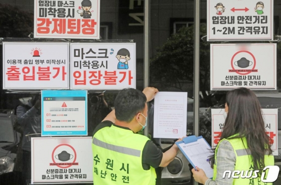 지난 11일 오후 경기도 수원시내 한 클럽에서 수원시청 관계자들이 신종 코로나바이러스 감염증(코로나19) 확산 방지를 위한 집합금지명령서를 부착하고 있다./사진=뉴스1
