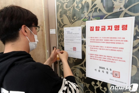 (서울=뉴스1) = 10일 강남구청 직원이 코로나19 확산 방지를 위해 관내 유흥시설에 집합금지 행정명령서를 부착하고 있다.강남구(구청장 정순균)는 관내 유흥시설을 현장 방문해 집합금지 공문을 전달하고 행정명령서를 출입구 정문에 부착, 행정명령 기간이 끝날 때까지 강남·수서 경찰서와 합동단속반을 구성하여 지속적으로 행정 명령 이행사항을 점검하고, 이행하지 않을 경우 관할 경찰서에 업소를 고발 조치할 예정이다. (강남구 제공) 2020.5.10/뉴스1