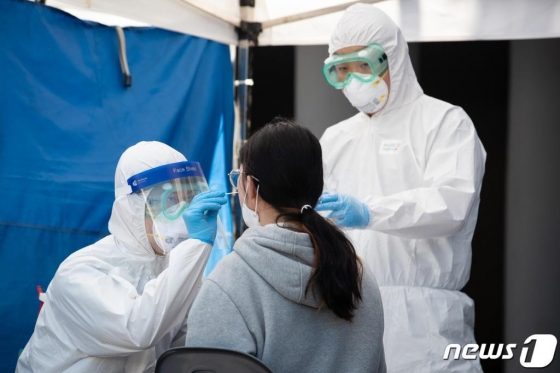 경기 부천 쿠팡 물류센터발 신종 코로나바이러스 감염증(코로나19) 확진자가 속출한 가운데 27일 부천종합운동장 주차장에 마련된 코로나19 선별진료소에서 방역당국 관계자들이 한 시민의 검체 채취를 하고 있다./사진=뉴스1