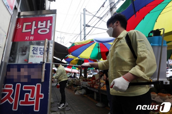 이태원 클럽발’ 신종 코로나 바이러스 감염증(코로나19) 지역 확산이 이어지고 있는 26일 오후 확진자가 방문한 서울 성동구 식당 인근 금남시장에서 금호동주민센터 관계자가 방역작업을 하고 있다./사진=뉴스1
