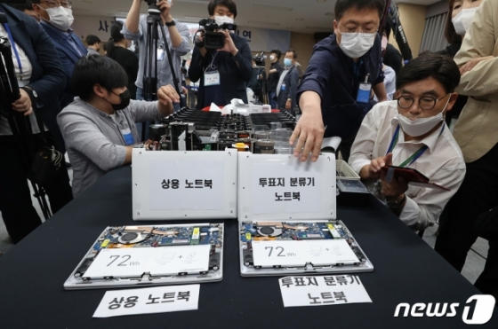 28일 경기도 과천 중앙선거관리위원회에서 4·15 총선 부정선거 주장에 대한 의혹을 해소하기 위해 열린 '사전투표 및 개표 공개 시연회'에서 관계자들이 투표지 분류기 노트북을 분해하고 있다/사진=뉴스1