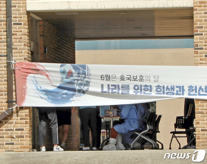 12일 오후 광주 서구 유촌동 한 중학교에서 코로나19 의심 증상을 보인 학생이 발생, 보건당국이 현수막으로 간이 칸막이를 만든 후 전 학생을 대상으로 코로나19 검사를 진행하고 있다.2020.6.12 /뉴스1 &copy; News1 허단비 기자