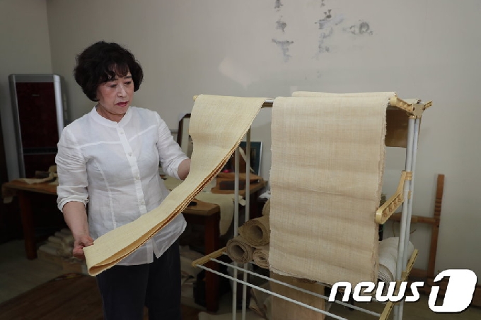 전통의 명맥을 잇고 있는 전남 보성삼베 수의 제작의 장인 박영남씨가 삼베 원단을 살펴보고 있다.(보성군 제공)/뉴스1