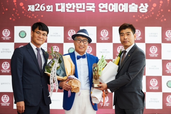 김명환 덕신하우징 회장(가운데)이 대한민국 연예예술상 신인상을 수상해 덕신하우징의 최영복 대표(왼쪽)과 김용회 대표(오른쪽)가 축하해주고 있다 /사진=덕신하우징