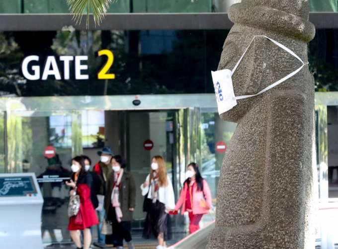 제주국제공항을 통해 관광객들이 입도하는 가운데 돌하르방이 코로나19 예방 마스크를 쓰고 있다. /사진=뉴시스