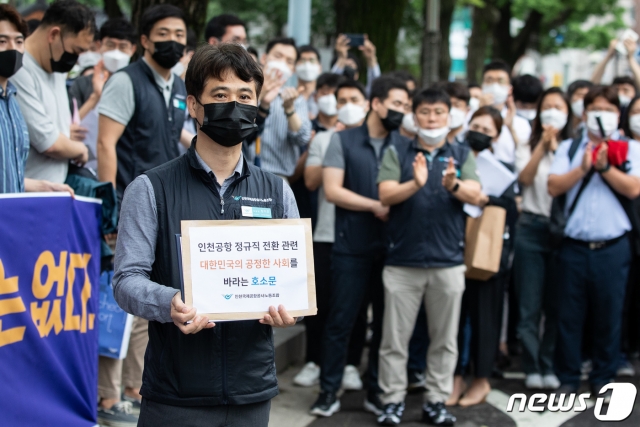 장기호 인천국제공항공사 노조 위원장이 25일 청와대 인근에서 비정규직 보안검색요원 직접고용전환과 관련해 입장을 밝힌 후 호소문을 청와대에 전달하기 위해 이동하고 있다. 이들은 '공사가 지난 2월 비정규직과 정규직이 2년 반에 걸쳐 합의한 정규직 전환합의를 무시하고 일방적인 정규직화(직고용) 추진을 발표했다'며 불공정한 전환과정에 반대한다고 밝혔다/사진=뉴스1