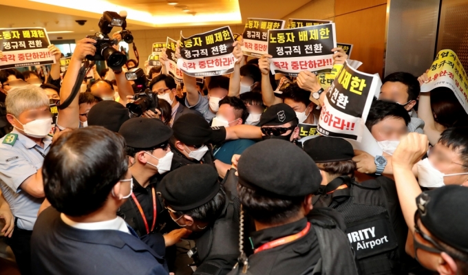 구본환 인천국제공항공사 사장이 22일 오후 인천공항1터미널에서 열린 기자회견에서 정규직 전환에 대한 입장을 밝히고 퇴장하자 '노동자 배제한 정규직 전환 즉각 중단하라'는 내용의 피켓을 든 노동조합원들이 항의를 하고 있다. /사진제공=뉴스1