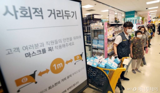 24일 오후 서울 성동구 이마트 성수점에서 시민들이 비말 차단용 마스크 구매에 앞서 받은 번호표와 마스크를 교환하고 있다. / 사진=이기범 기자 leekb@