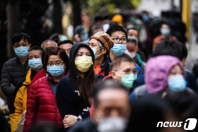 중국발 신종 코로나바이러스 감염 예방을 위해 마스크 쓴 홍콩 시민들이 5일(현지시간) 새로 마스크를 구입하기 위해 몇 시간째 밖에 줄 서 있다. 6일 0시 기준 홍콩 내 신종 코로나 확진자 21명, 사망자는 1명에 이른다./사진=(홍콩 AFP=뉴스1)