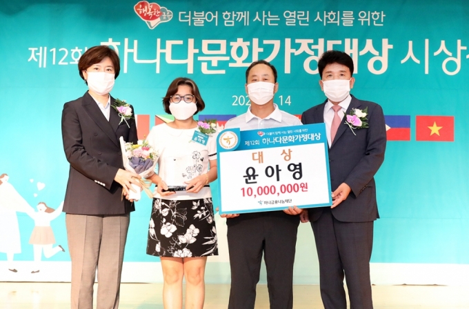 하나금융나눔재단은 지난 14일 오후 하나금융그룹 명동 사옥 대강당에서 「제12회 하나다문화가정대상」 시상식을 개최했다. 함영주 하나금융나눔재단 이사장(사진 맨 오른쪽)과 김희경 여성가족부 차관(사진 맨 왼쪽)이 대상인 여성가족부장관상을 수상한 윤아영 씨(사진 왼쪽에서 두번째)부부와 함께 기념촬영을 하고 있다.