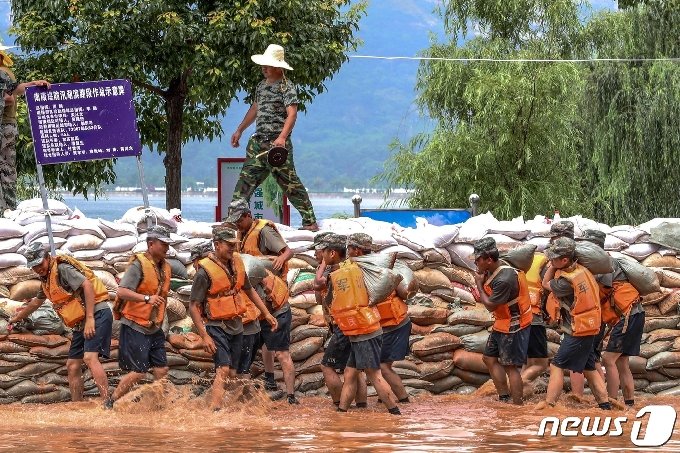 [사진] 흙탕물 속 포양호 임시제방 쌓는 中 군인들