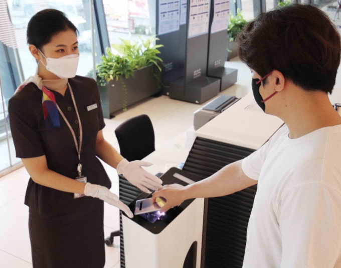 김포국제공항 국내선 탑승 승객이 아시아나항공 직원의 안내를 받아 핸드폰 모바일 탑승권으로 셀프 보딩을 하고 있다./사진제공=아시아나항공