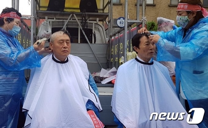 24일 충북도청 앞에서 한국공인중개사협회 충북지부 임원 2명이 정부의 6&middot;17 부동산 대책으로 청주 동지역과 오창&middot;오송읍이 조정대상지역에 포함된 것과 관련해 지정 해제를 촉구하며 삭발을 하고 있다.2020.7.24. &copy; 뉴스1