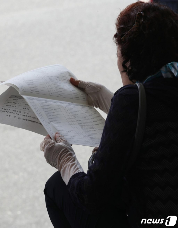 (울산=뉴스1) 윤일지 기자 = 2일 울산 동구청 앞 광장에서 '코로나19 극복을 위한 희망일자리 채용박람회'가 개최된 가운데 한 구직자가 채용정보를 확인하고 있다. 동구는 구민들에게 공공분야 희망일자리를 제공해 생계지원과 지역경제 활력을 도모하고자 채용박람회를 마련했다. 채용박람회는 이날부터 3일까지 열린다. 2020.7.2/뉴스1