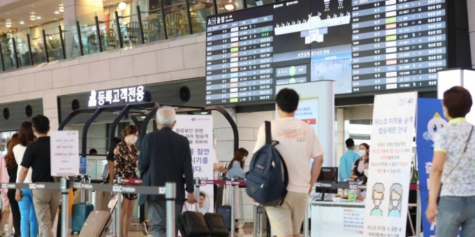 본격적인 휴가철을 맞은 지난 27일 오전 서울 강서구 김포공항 국내선 청사에서 코로나19로 해외 대신 국내여행을 떠나는 여행객들이 탑승장으로 가기 위해 줄을 서고 있다. /사진=뉴시스