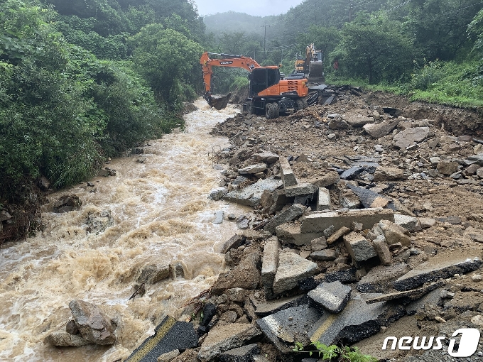 2일 오전 충북 충주소방서 소방관이 실종된 산척면 명서리 도로에서 굴삭기 2대가 무너진 토사를 도로쪽으로 옮기고 있다.2020.8.2 /© 뉴스1