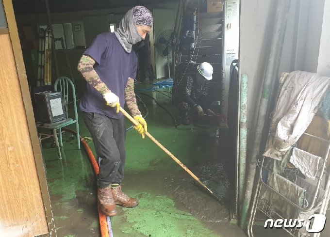 물이 1m 이상 들어 차 침수피해를 입은 점포 바닥을 직원이 닦고 있다.© 뉴스1
