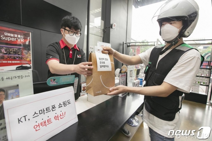 (서울=뉴스1) = KT는 공식 온라인몰 KT샵에서 ‘1분주문 & 1시간배송’ 서비스를 오픈한다고 1일 밝혔다. ‘1분주문’은 KT샵에서 핸드폰으로 본인인증을 하면 사용 중인 요금제를 기준으로 핸드폰 가격을 확인할 수 있다. 여기서 구매를 원하는 핸드폰을 고르면 선택약정과 공시지원금 할인 중 혜택이 더 큰 쪽이 기본값으로 입력된다. ‘1시간배송’ 서비스는 KT샵에서 핸드폰을 주문하면, 고객이 배송을 받아보고자 하는 위치를 기반으로 가까운 대리점에서 단말을 준비해 배송해주는 서비스다. KT 대리점 직원이 부릉 라이더에게 ‘1시간배송’ 서비스를 통한 핸드폰 배송을 요청하고 있다. (KT 제공) 2020.7.1/뉴스1