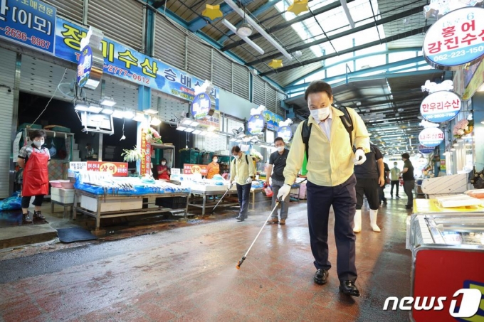 지난달 7일 광주 동구 남광주시장에서 임택 동구청장과 주민자치계 직원 등이 신종 코로나바이러스 감염증(코로나19) 지역 확산 예방을 위해 방역 소독하고 있다. /사진=뉴스1