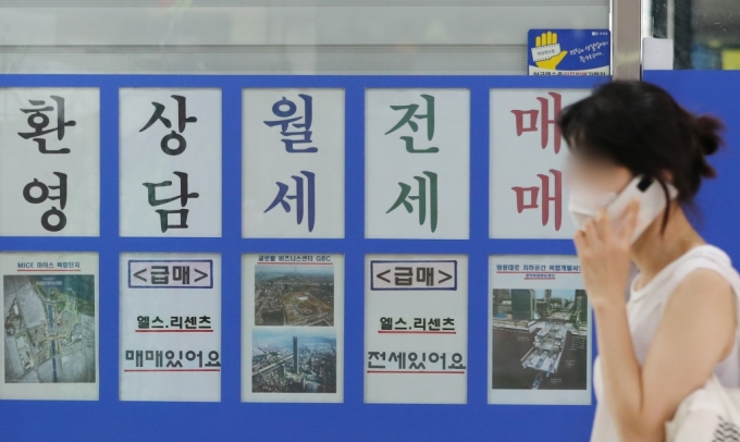 부가 '8.4 주택공급대책'을 통해 서울 재건축·재개발 관련 규제를 조건부로 완화하기로 결정하면서 강남권 정비사업 추진에 대한 기대감이 높아지고 있는 가운데 4일 오후 송파구의 한 부동산 앞으로 한 시민이 지나가고 있다./사진제공=뉴스1