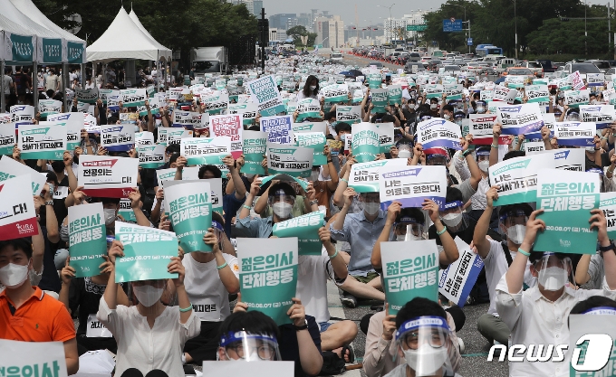 의과대학 정원 확대 방안에 반대하는 전공의들이 지난 7일 서울 영등포구 여의대로에서 피켓을 들고 있다./뉴스1 &copy; News1