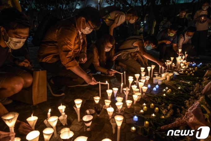 (홍콩 AFP=뉴스1) 지난 6월 (현지시간) 홍콩 시민들이 텐안먼 시위 31주년을 맞아 침사추이 해변에서 시위 희생자를 추모하는 촛불을 켜고 있다. ⓒ AFP=뉴스1