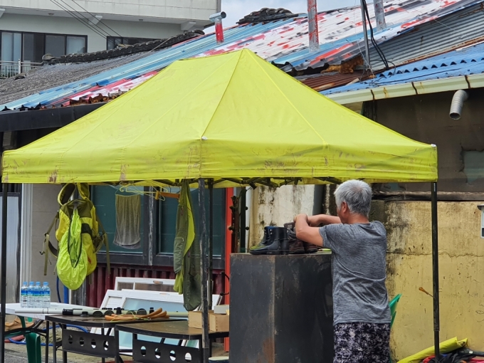 물에 젖은 신발을 정리하는 재해 주민 /사진=머니투데이