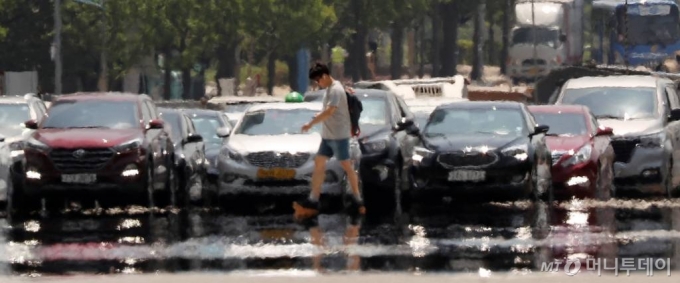 서울 낮 최고기온이 35도까지 오르며 폭염주의보가 내려진 지난 6월22일 오후 서울 영등포구 여의대로에 아지랑이가 피어오르고 있다. / 사진=김휘선 기자 hwijpg@