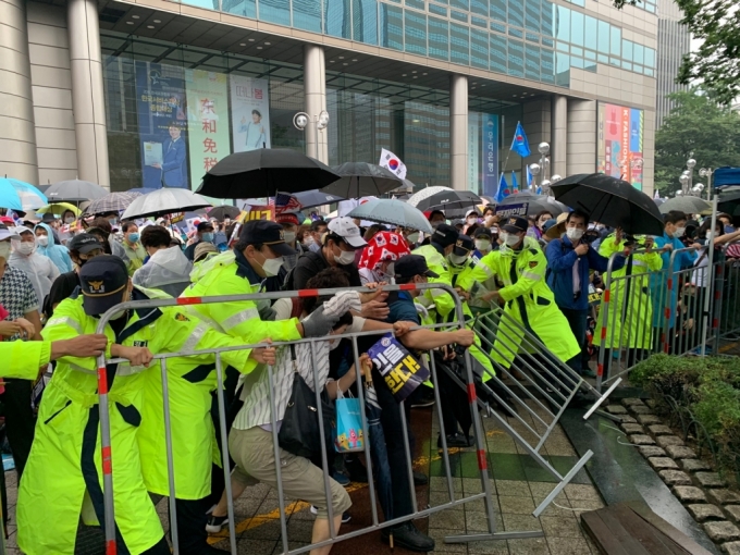 15일 정오 서울 종로구 동화면세점 인근 광화문 일대에서 경찰 통제에 불응한 집회 참가자들이 펜스를 무너뜨리고 있다./사진=이강준 기자
