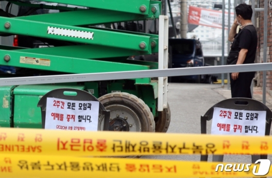 (서울=뉴스1) 김명섭 기자 = 교인이 14일 서울 성북구 장위동 사랑제일교회에서 신종 코로나바이러스 감염증(코로나19) 집단발병으로 통제선이 설치된 모습을 보고 있다. 사랑제일교회에서 단 이틀만에 13명이 코로나19 확진되는 등 급속히 퍼져나가고 있어 방역당국이 시설폐쇄조치를 내렸다. 2020.8.14/뉴스1