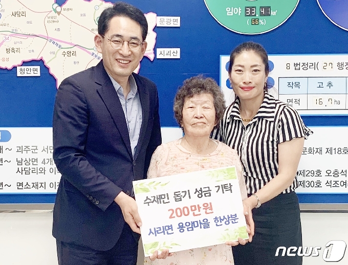 괴산군 사리면 한상분씨가 주민자치센터에 수재민을 위해 써달라며 절약해 모은 200만원을 전달하고 있다.(괴산군 제공)© 뉴스1