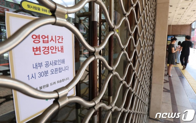 대구 중구 동성로 대구백화점 1인 매장에 근무하는 직원이 신종 코로나바이러스 감염증(코로나19) 확진 판정을 받은 것으로 알려진 가운데 25일 오전 출입이 폐쇄된 백화점 입구에서 시민들이 영업재개를 기다리고 있다. /사진=뉴스1