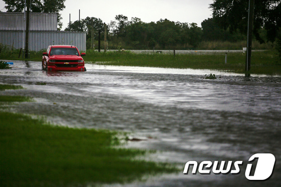 27일(현지시간) 허리케인 로라가 접근한 루이지애나주 애브빌에서 주민들이 대피한 가운데 차량이 물에잡겨 있다. ⓒ 로이터=뉴스1