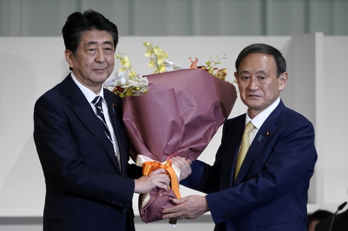 지난 14일 일본 자민당 신임 총재에 당선된 스가 요시히데 관방장관(오른쪽)과 아베 신조 총리(왼쪽). /AFPBBNews=뉴스1