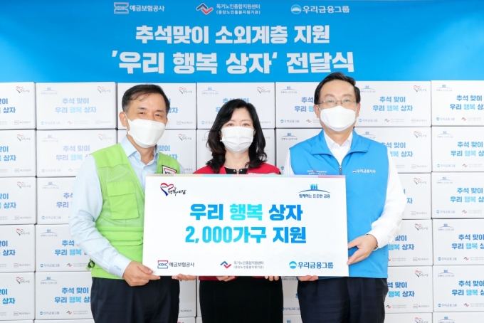 우리금융그룹과 예금보험공사는 추석을 맞아 홀로 계신 어르신들이 따뜻한 한가위를 보낼 수 있도록 우리 농산품으로 채워진 '우리행복상자' 2000개를 지난 15일 독거노인종합지원센터에 전달했다. 손태승 우리금융그룹 회장(오른쪽), 김현미 독거노인종합지원센터장(가운데), 위성백 예금보험공사 사장(왼쪽)이 우리행복상자 전달식 기념촬영을 하고 있다./사진제공=우리금융그룹