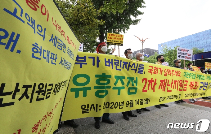 한국유흥음식중앙회 회원과 유흥주점 관계자 등 참석자들이 지난 14일 오전 서울 여의도 국회 앞에서 '유흥주점 2차 재난지원금 제외 규탄 기자회견'을 하고 있다. 2020.9.14 /뉴스1 © News1 성동훈 기자
