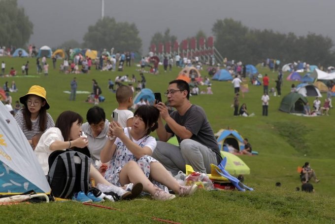 30일 중국 베이징 외곽 옌칭에서 야영을 즐기는 사람들이 휴대전화로 사진을 찍고 있다. 중국 국가위생건강위원회는 전날 발생한 코로나19 신규 확진자는 17명이며 이들은 모두 해외에서 유입됐으며 중국 내 본토 감염 사례는 보름째 ‘0’을 기록하고 있다고 31일 밝혔다. 2020.08.31./사진=[베이징=AP/뉴시스]