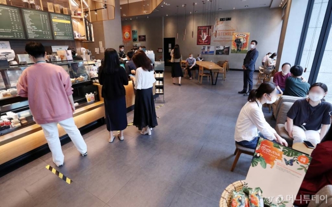 사회적 거리두기 조치가 2단계로 완화되며 수도권 지역 프랜차이즈 커피전문점 매장 내 좌석 이용이 가능해진 지난 14일 서울 종로구 한 카페를 찾은 고객들이 매장을 방문하고 있다. / 사진=김휘선 기자 hwijpg@